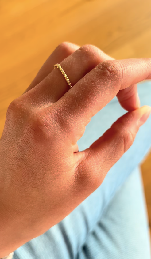 Frau trägt Champagner Ring von Sarah Cossham am Finger